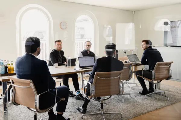 Fünf Männer unterhalten sich in einem Konferenzraum des Kontora Family Offices